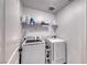 Practical laundry room with modern washer and dryer, and shelving for storage solutions at 10025 San Floriano St, Las Vegas, NV 89178
