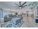 Open floor plan with spacious gray sectional and ottoman, tile floors, and backyard access at 10025 San Floriano St, Las Vegas, NV 89178