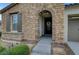 Close-up of the front entry showcasing a stone archway, wooden door, and landscaped garden at 1005 Old Creek Way, North Las Vegas, NV 89084