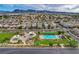 Aerial view of neighborhood with pool, playground, and green space surrounded by many single Gathering homes at 1055 Fish Pond Ave, Henderson, NV 89014