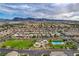 High aerial view of community featuring many single-Gathering homes, green space, playground, pool and mountain views at 1055 Fish Pond Ave, Henderson, NV 89014