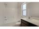 Bathroom featuring a large tub-shower combination, vanity with sink and stone countertops at 1055 Fish Pond Ave, Henderson, NV 89014