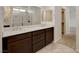 Bathroom featuring double sinks, dark wood cabinets, and a large mirror at 1055 Fish Pond Ave, Henderson, NV 89014