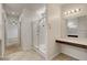 Bright bathroom featuring a glass shower, neutral tile, and a vanity area with stylish lighting at 1055 Fish Pond Ave, Henderson, NV 89014