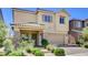Charming two-story home featuring a stucco exterior, stone accents, and a well-manicured front yard at 1055 Fish Pond Ave, Henderson, NV 89014