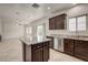 Kitchen island with granite countertops, stainless dishwasher and dark cabinets at 1055 Fish Pond Ave, Henderson, NV 89014