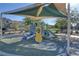 Community playground with slides, climbing structures, and shade canopies, set amidst landscaped surroundings, and green spaces at 1055 Fish Pond Ave, Henderson, NV 89014