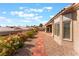 Landscaped backyard featuring a brick walkway, decorative rock, and mature plants at 10901 Fort Valley Ave, Las Vegas, NV 89134
