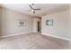 Neutral bedroom featuring a ceiling fan, and view to hallway with decorative paintings at 10901 Fort Valley Ave, Las Vegas, NV 89134