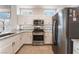 Kitchen with stainless steel appliances, white cabinets, and granite countertops at 10901 Fort Valley Ave, Las Vegas, NV 89134