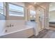 Clean bathroom featuring a soaking tub, a glass-enclosed shower, and wood look floors at 1220 Eva Creek Dr # 35, North Las Vegas, NV 89084