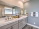 Modern bathroom featuring double sinks, a large mirror, and neutral color palette at 1220 Eva Creek Dr # 35, North Las Vegas, NV 89084