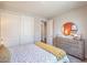 Bright bedroom showcasing large closet, dresser with a mirror, and a queen bed with colorful bedding at 1220 Eva Creek Dr # 35, North Las Vegas, NV 89084