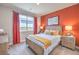 Cozy bedroom featuring a queen bed, red accent wall, and natural light from the window at 1220 Eva Creek Dr # 35, North Las Vegas, NV 89084