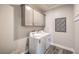 Functional laundry room with gray cabinets, a stacked washer and dryer, and geometric wall art at 1220 Eva Creek Dr # 35, North Las Vegas, NV 89084