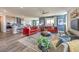 Spacious living room with two red sofas, an accent wall, and an open layout to the kitchen at 1220 Eva Creek Dr # 35, North Las Vegas, NV 89084