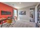 Bright home office space with a red accent wall and neutral carpet at 1220 Eva Creek Dr # 35, North Las Vegas, NV 89084