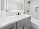 Bathroom vanity with granite countertop, modern mirror and a tub with a showerhead at 1305 Pagentry Dr, North Las Vegas, NV 89031