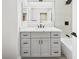 Bathroom vanity with modern lighting, granite countertop, and gray cabinetry over a tub and shower at 1305 Pagentry Dr, North Las Vegas, NV 89031