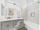 Modern bathroom featuring a double vanity, illuminated mirror, and a bathtub with sleek tile surround at 1305 Pagentry Dr, North Las Vegas, NV 89031