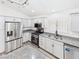 White kitchen cabinets with stainless steel appliances and granite countertops at 1305 Pagentry Dr, North Las Vegas, NV 89031