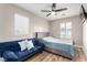 Inviting bedroom with fan, couch, and bed featuring neutral walls and wood flooring at 1360 Angel Falls St, Las Vegas, NV 89142