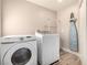 Functional laundry room featuring modern machines, wood floors, and neutral tones at 1360 Angel Falls St, Las Vegas, NV 89142