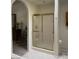 Clean bathroom featuring a glass-enclosed shower with gold trim, complemented by tiled flooring at 1461 E Elderberry St, Pahrump, NV 89048
