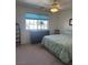 Bright bedroom with large window, ceiling fan, and cozy carpeting at 1461 E Elderberry St, Pahrump, NV 89048