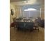 Dining room with wooden table and chairs, tile flooring, a pendant chandelier and window with blinds at 1461 E Elderberry St, Pahrump, NV 89048