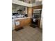 Kitchen with wooden cabinets, tile backsplash, laminate countertops, stainless steel appliances and tile floors at 1461 E Elderberry St, Pahrump, NV 89048