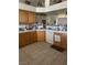 Kitchen with wooden cabinets, tile backsplash, laminate countertops, white appliances and tile floors at 1461 E Elderberry St, Pahrump, NV 89048
