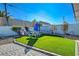 Lush backyard with an artificial lawn, outdoor seating, and privacy fence at 1631 Ottawa Dr, Las Vegas, NV 89169