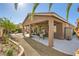 Backyard with covered patio, gravel landscaping, outdoor seating, and mature trees creating a tranquil retreat at 1641 Blue Cliffs Ave, Henderson, NV 89014