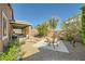 Serene backyard with gravel landscaping, a covered patio, and mature trees offering a private outdoor space at 1641 Blue Cliffs Ave, Henderson, NV 89014