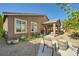 Relaxing backyard with a covered patio, gravel landscaping, and mature trees for shade and privacy at 1641 Blue Cliffs Ave, Henderson, NV 89014