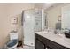 Modern bathroom with a glass-enclosed shower, toilet, vanity, and a sleek dark-colored cabinet with a white countertop at 1641 Blue Cliffs Ave, Henderson, NV 89014