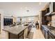 Modern kitchen with granite countertops and stainless steel appliances opening to the living room at 1641 Blue Cliffs Ave, Henderson, NV 89014