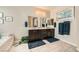 Bright and modern bathroom features tile floors, double sinks, large mirror, and bathtub at 1641 Blue Cliffs Ave, Henderson, NV 89014