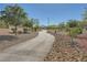 Community walking path lined with decorative rock, shrubbery and mature shade trees at 1641 Blue Cliffs Ave, Henderson, NV 89014