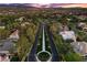 Aerial view of a luxury community entrance road lined with trees, manicured greenery, and fountains at 2268 Buckingham Ct, Henderson, NV 89074