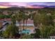 Sunset aerial view of a beautiful backyard with pool, covered patio, and palm trees at 2268 Buckingham Ct, Henderson, NV 89074