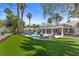 Lush backyard boasts a pool with a waterfall feature, comfortable seating, and manicured landscaping at 2268 Buckingham Ct, Henderson, NV 89074