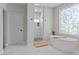 Bright bathroom with a walk-in shower, bathtub, cabinets, a rug, and a unique window at 2268 Buckingham Ct, Henderson, NV 89074