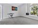 Spacious room featuring gray carpet, a keyboard, and a window with a view of a palm tree at 2268 Buckingham Ct, Henderson, NV 89074