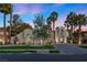 Elegant single-story home with lush landscaping, palm trees and a circular driveway at 2268 Buckingham Ct, Henderson, NV 89074