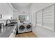 Bright laundry room features built-in cabinets, a window, and front-load washer and dryer at 2268 Buckingham Ct, Henderson, NV 89074