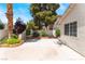 Landscaped backyard featuring a well-maintained concrete patio, mature trees, and a brick-lined garden bed at 25 Colbath St, Las Vegas, NV 89110