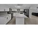 Modern white kitchen with stainless steel appliances and gray backsplash, open to a living space at 2635 Heritage Ct, Las Vegas, NV 89121