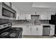 Kitchen showcases stainless steel appliances, white cabinetry, and sleek gray backsplash, offering a modern and functional space at 2635 Heritage Ct, Las Vegas, NV 89121